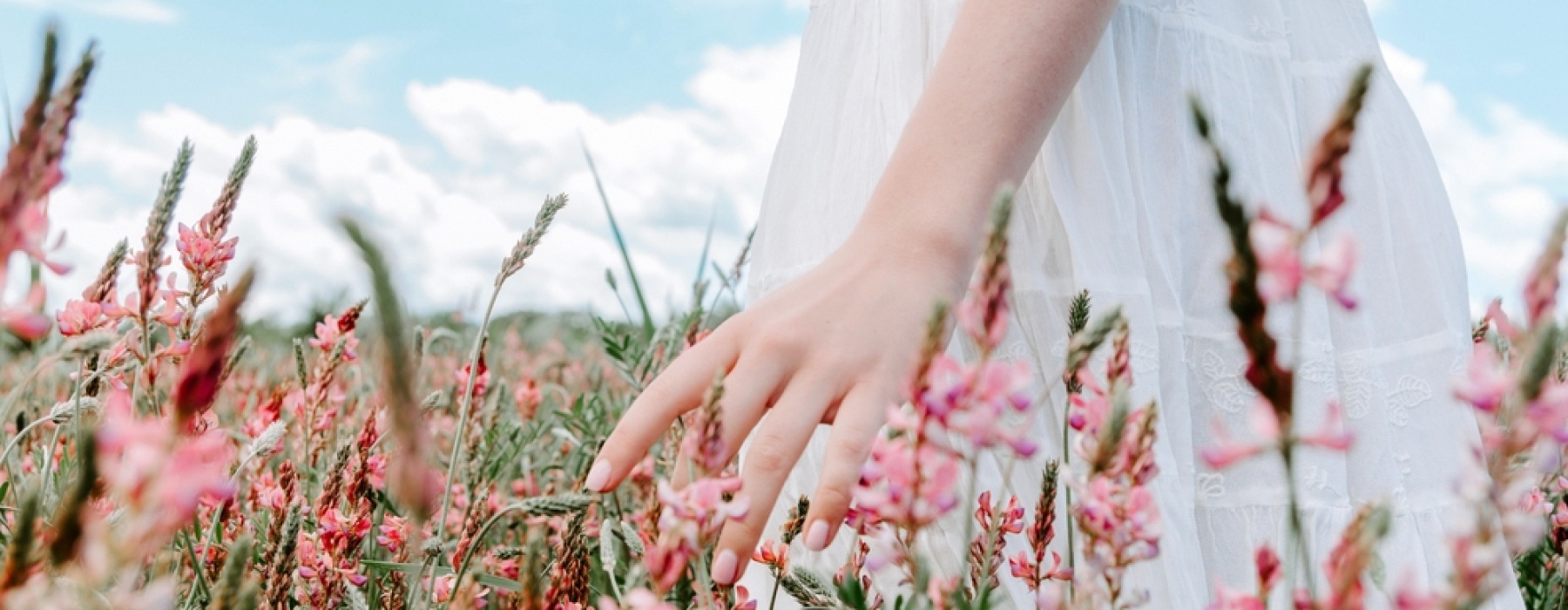 Woman walking through pink flowers