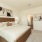 3 Bedroom Homes for rent in Rosharon TX - Alterra at Sierra Vista - Carpeted Bedroom with White Walls, a Large Bed, Nightstands, and an Attached Bathroom